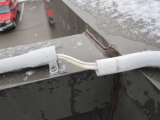 Separated conduit on roof cap requires repair.